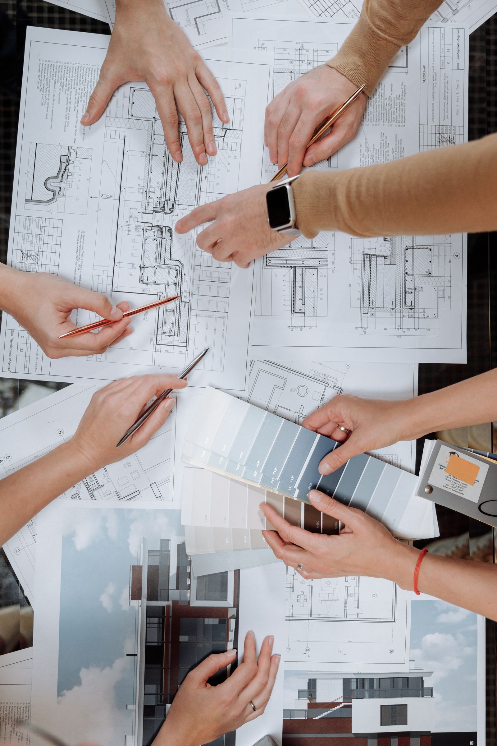 Mains réunies autour de plans et d'un nuancier