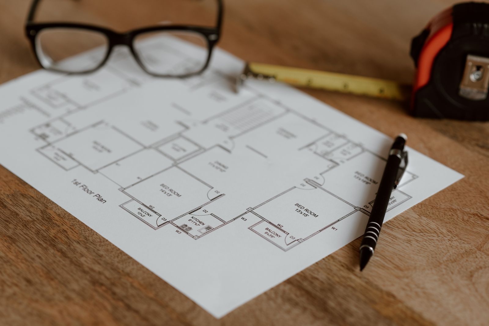 Plan de maison, lunettes et mètre ruban sur la table