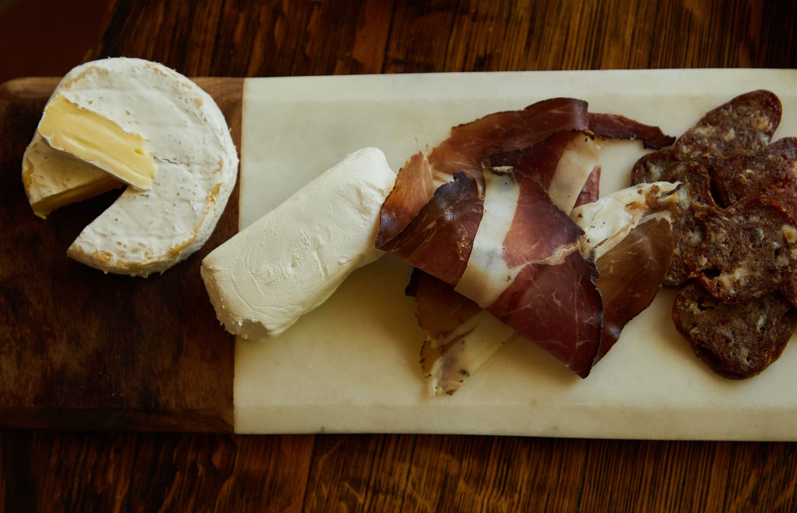 Planche de charcuterie et fromages sur le bois du comptoir