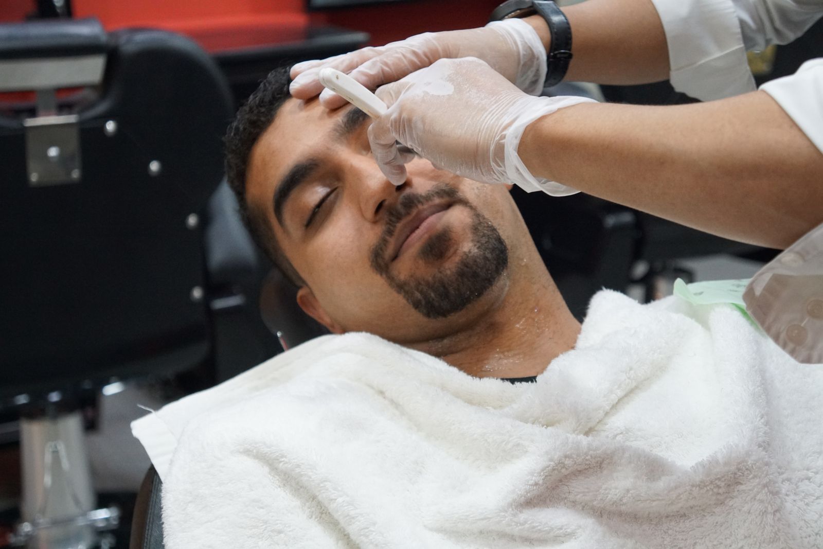 Client sous la serviette chaude avant le rasage