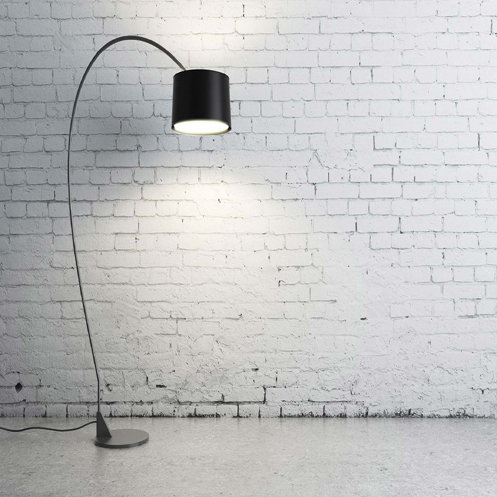 Lampadaire arc noir devant un mur de briques blanches