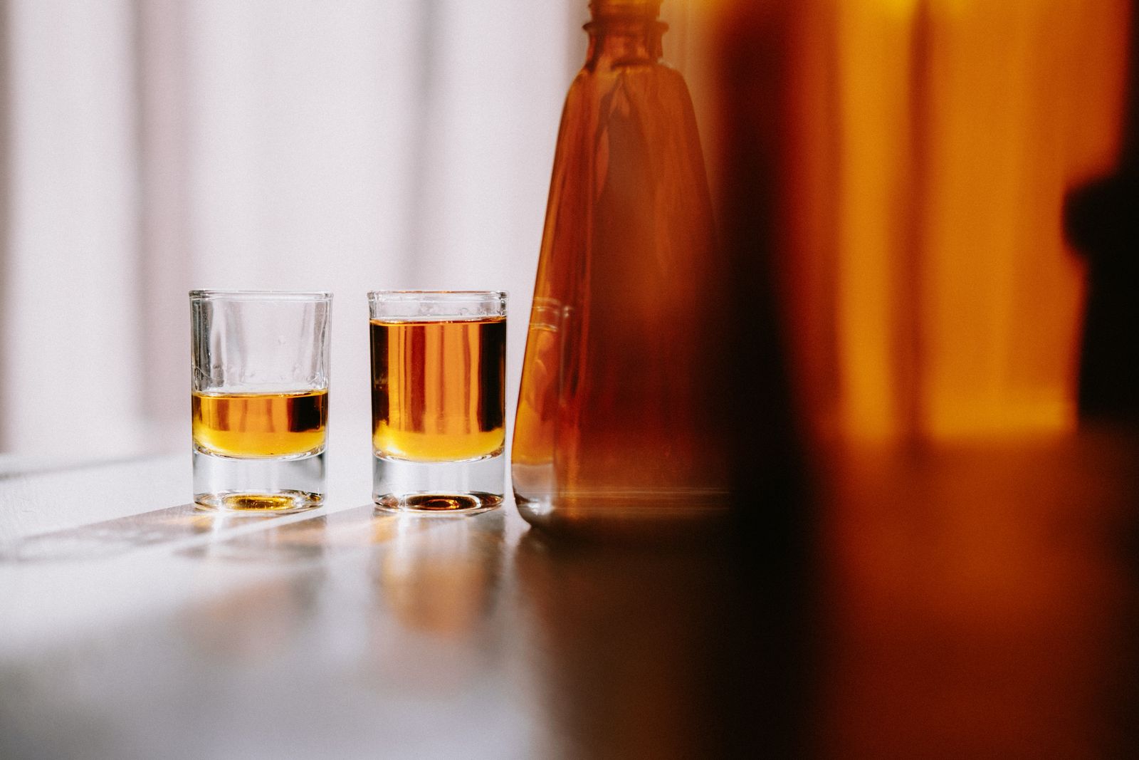 Deux petits verres d'armagnac ambré dans la lumière du soir