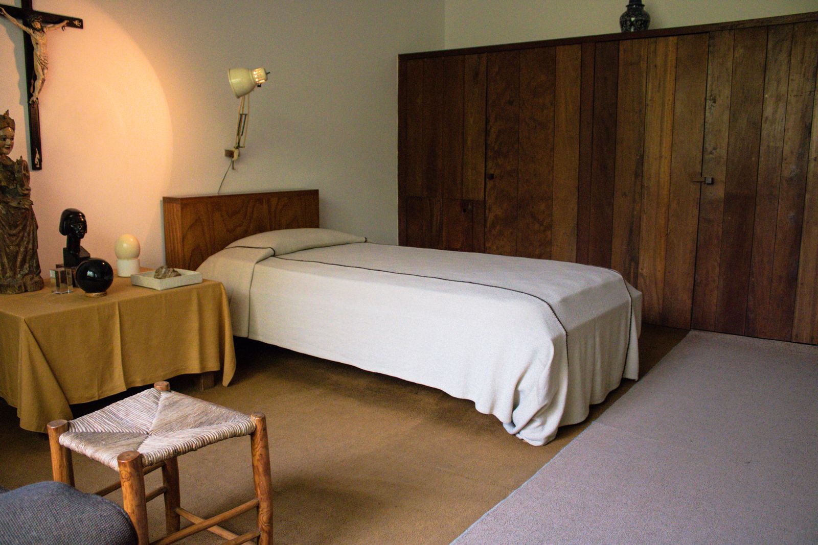 La chambre des Coteaux, armoire ancienne et dessus-de-lit crème dans une lumière douce
