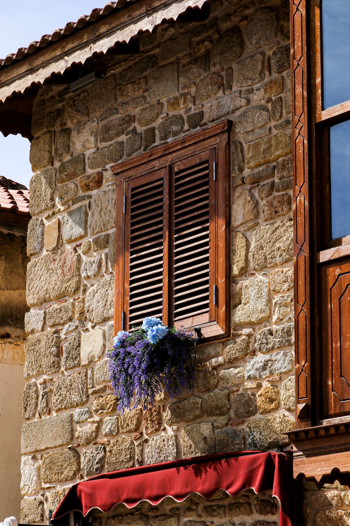 La pierre blonde de la façade, volets de bois et lavande à la fenêtre