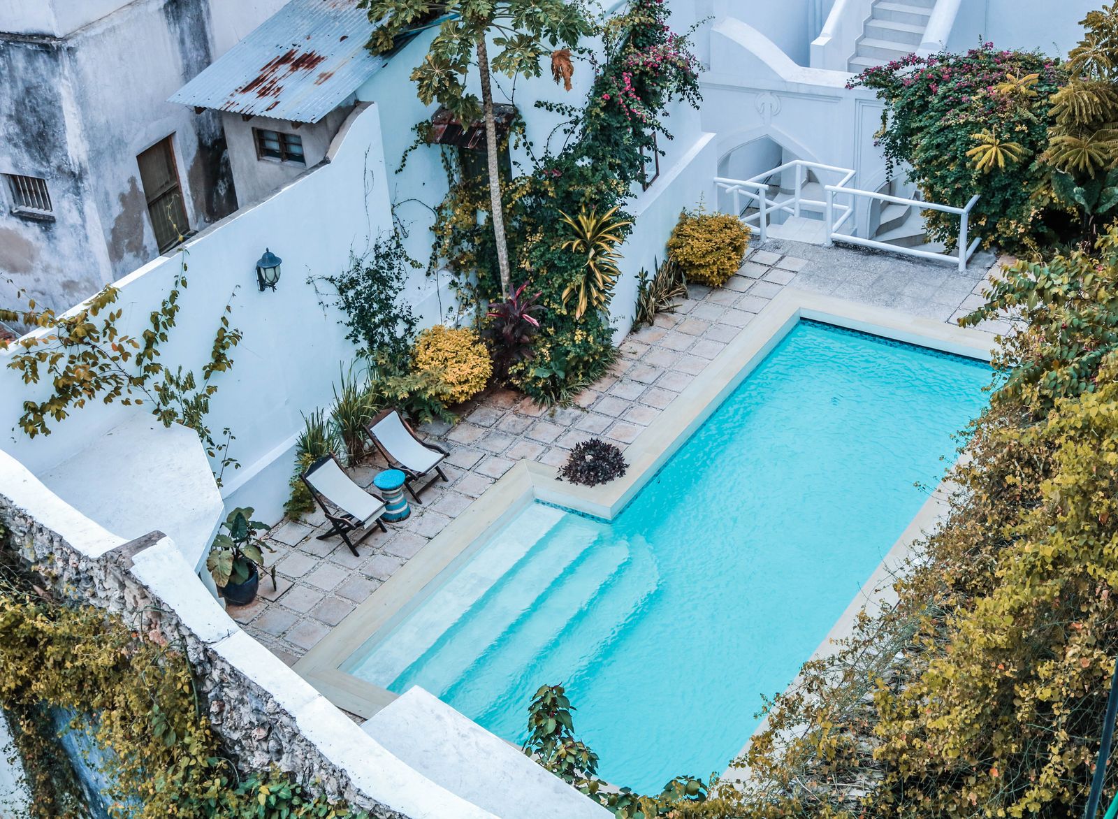 La piscine dans la cour, transats et pierre claire