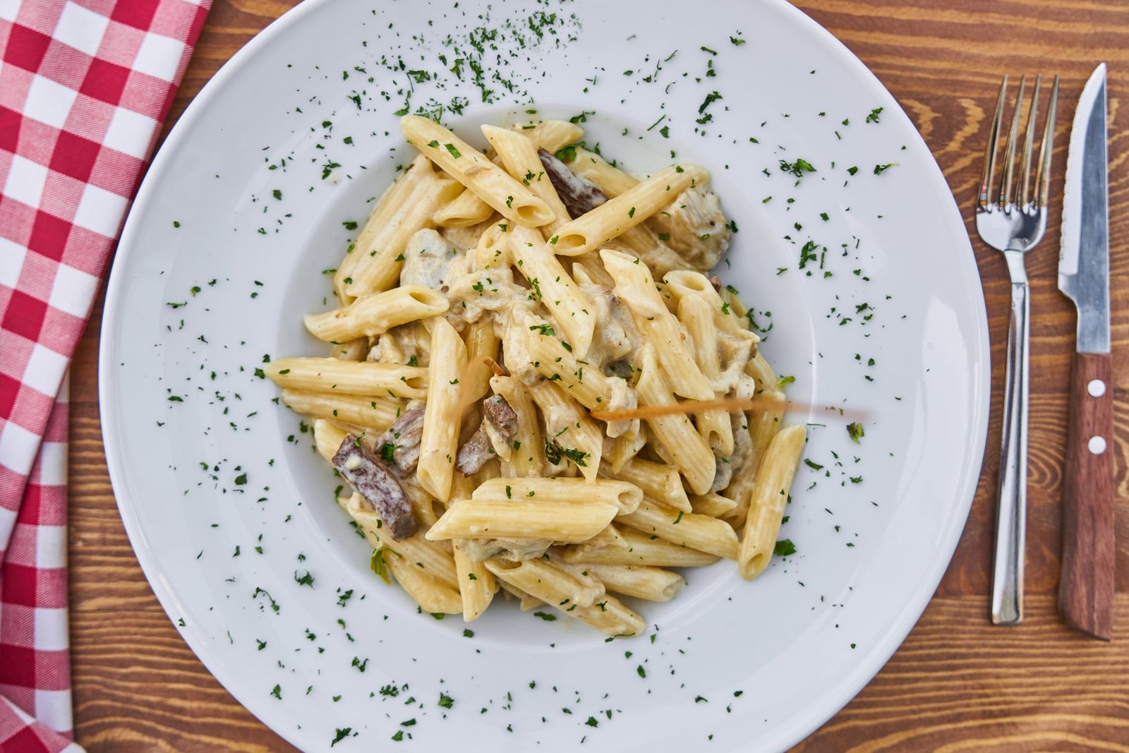Penne servies sur nappe vichy