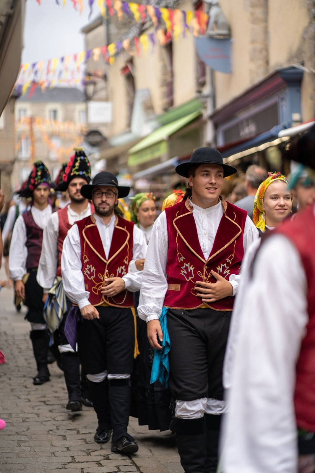 Défilé en costumes traditionnels dans la rue pavoisée