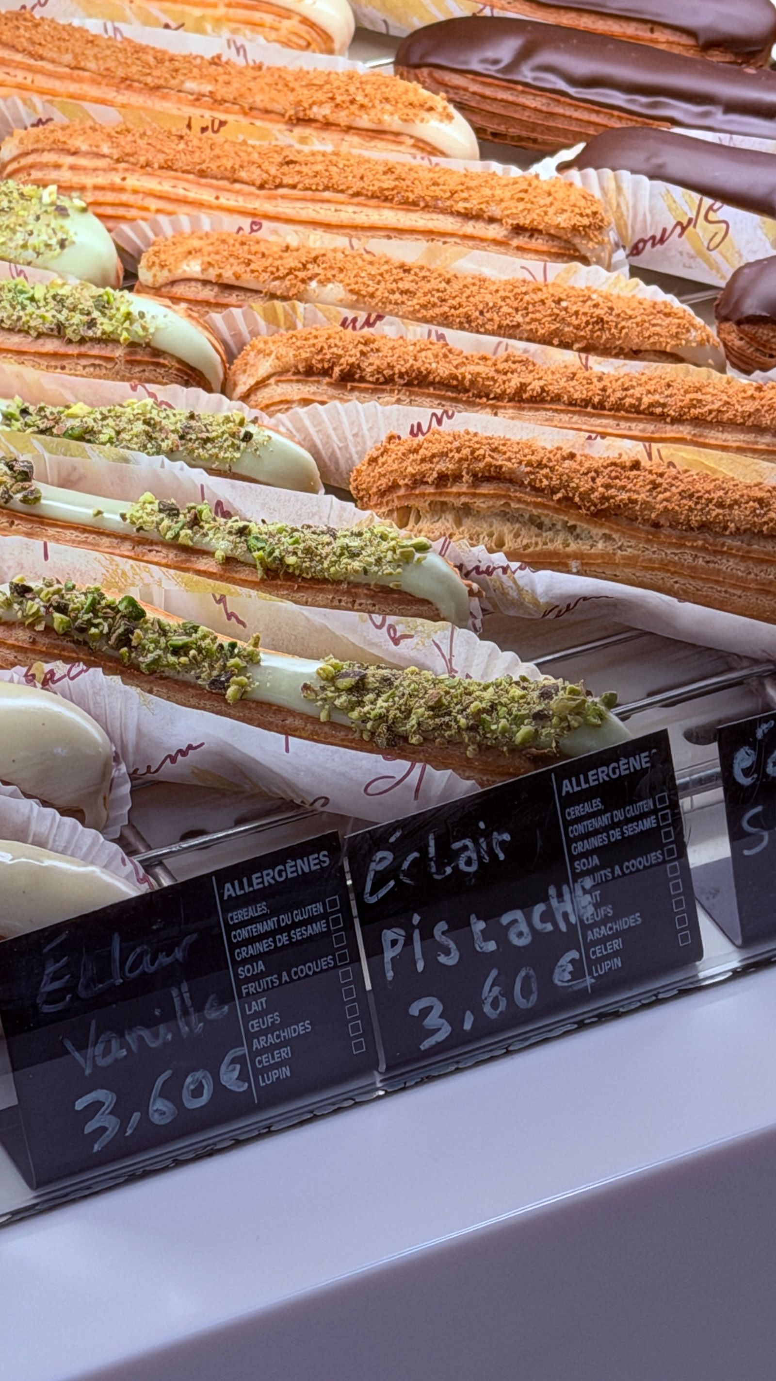 Les éclairs alignés en vitrine avec leurs étiquettes