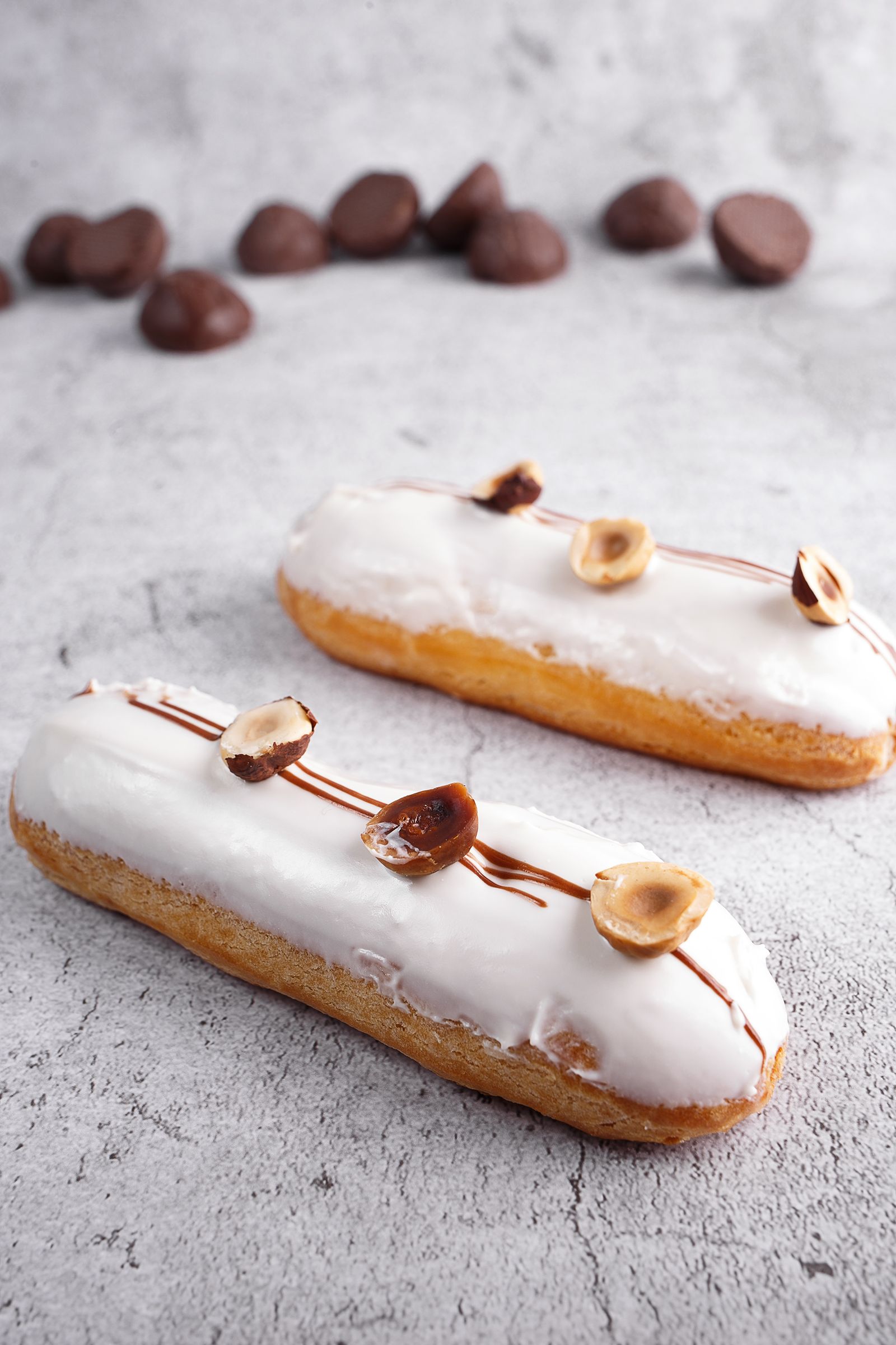 Éclairs glacés blanc et noisette sur le marbre