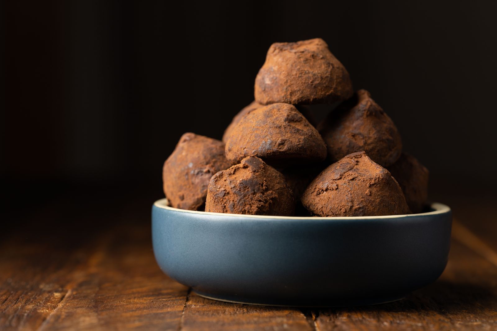 Truffes au cacao dans une coupelle sombre