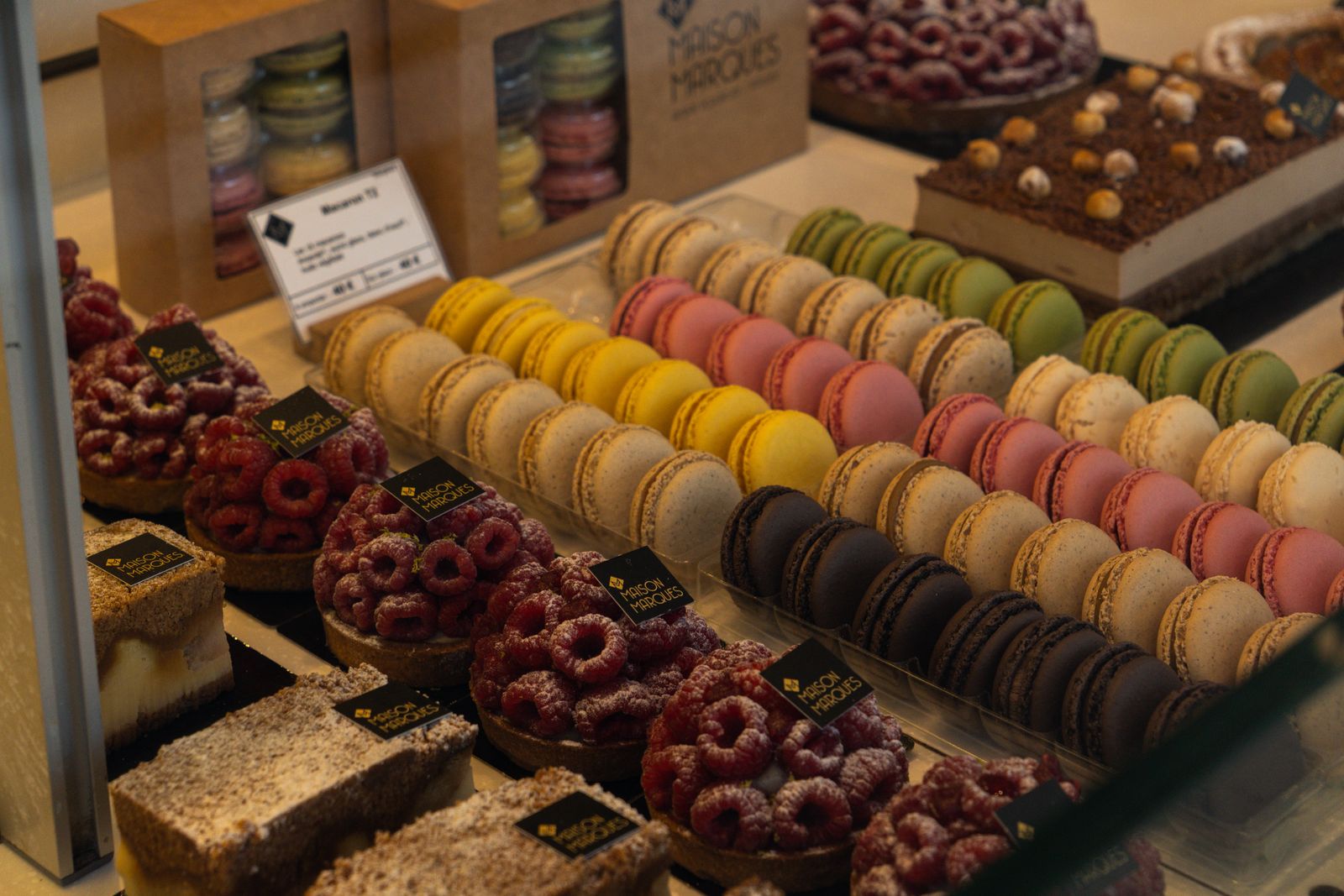 La vitrine réfrigérée, rangs de macarons et entremets