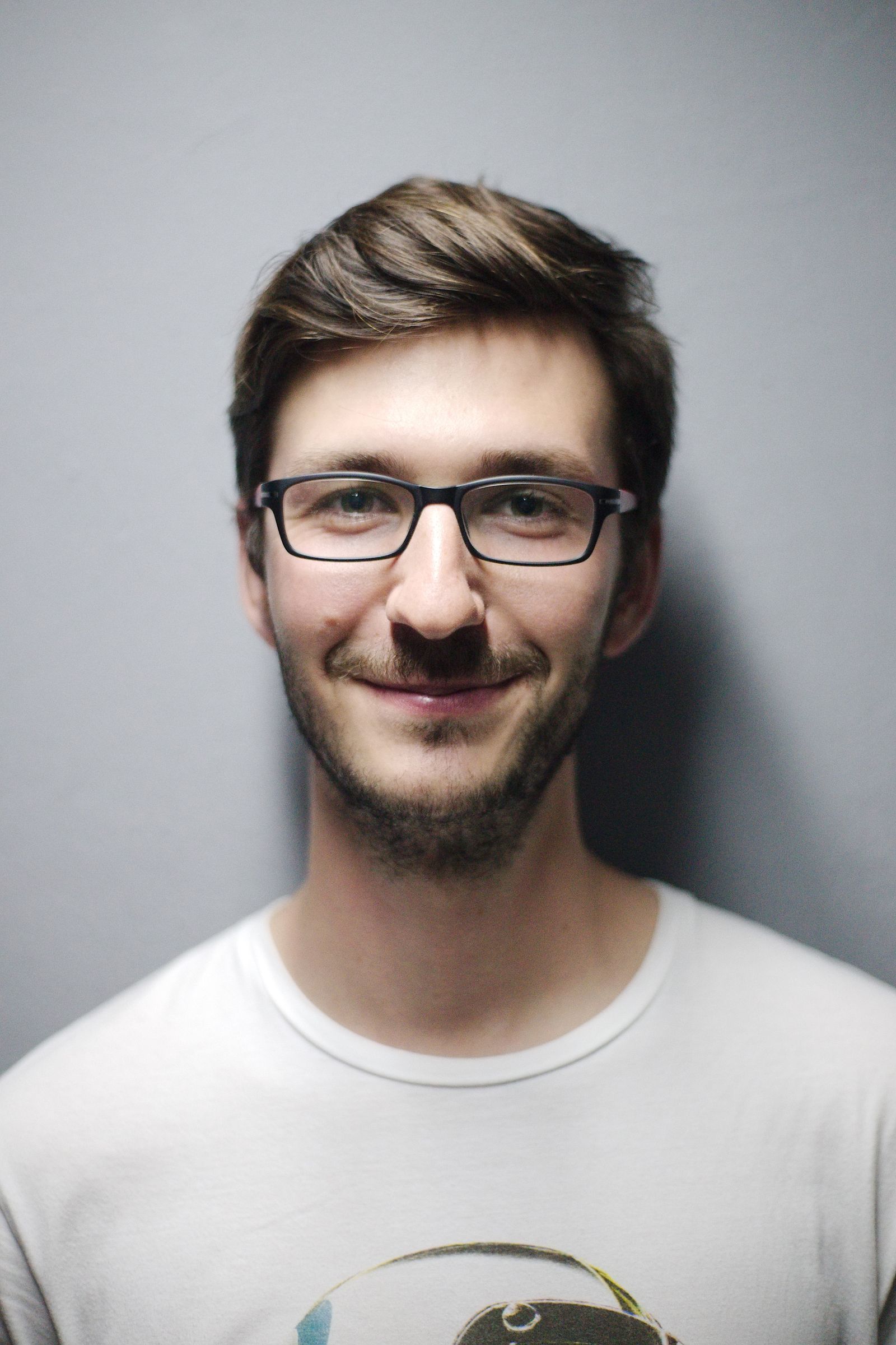 Portrait d'homme à lunettes sur fond gris neutre