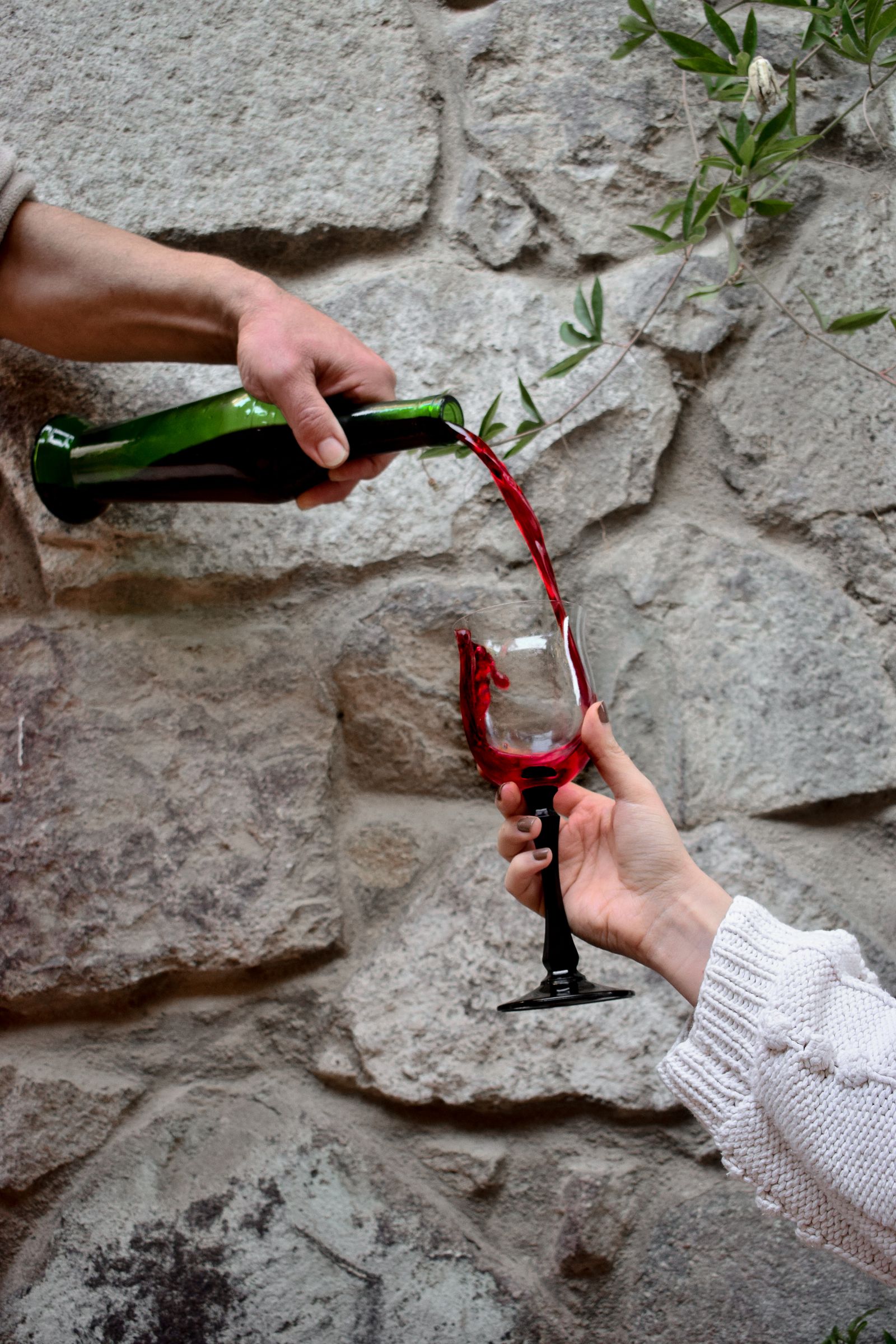 Vin rouge servi devant le mur de pierre du chai